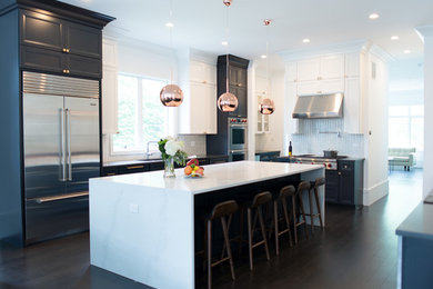 Large minimalist u-shaped dark wood floor and black floor eat-in kitchen photo with a single-bowl sink, flat-panel cabinets, black cabinets, quartz countertops, white backsplash, mosaic tile backsplash, stainless steel appliances and an island