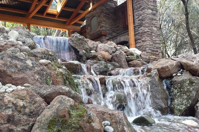 Photo of a large traditional partial sun hillside stone landscaping in Sacramento.