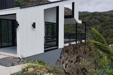 Example of a large urban white two-story metal exterior home design with a metal roof