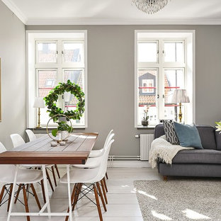 Nordisk inredning av en matplats med öppen planlösning, med grå väggar, ljust trägolv och vitt golv