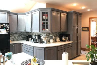 Mid-sized transitional l-shaped travertine floor and beige floor enclosed kitchen photo in New York with shaker cabinets, an undermount sink, light wood cabinets, quartzite countertops, gray backsplash, matchstick tile backsplash, stainless steel appliances, an island and beige countertops