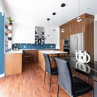 Foto de cocina comedor en U, moderna, de tamaño medio, con fregadero de doble seno, armarios con paneles lisos, puertas de armario de madera oscura, encimera de cuarzo compacto, salpicadero multicolor, salpicadero de azulejos de porcelana, electrodomésticos de acero inoxidable, suelo de madera oscura, una isla, suelo marrón y encimeras blancas