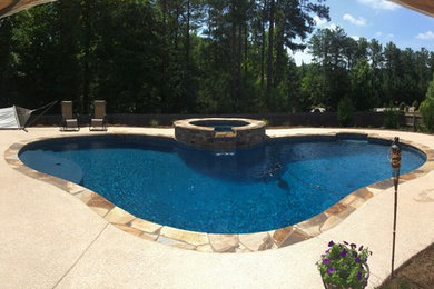 Example of a mid-sized arts and crafts backyard stone and kidney-shaped hot tub design in Atlanta