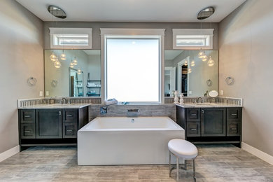 Example of a large transitional master gray tile and porcelain tile porcelain tile and gray floor bathroom design in Seattle with furniture-like cabinets, dark wood cabinets, a two-piece toilet, gray walls, an undermount sink and marble countertops