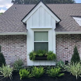 Großer Eklektischer Vorgarten mit Blumenbeet, direkter Sonneneinstrahlung und Mulch in Houston