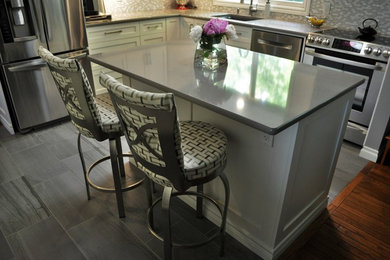 Inspiration for a mid-sized modern l-shaped kitchen remodel in Toronto with an undermount sink, shaker cabinets, white cabinets, granite countertops, stainless steel appliances and an island
