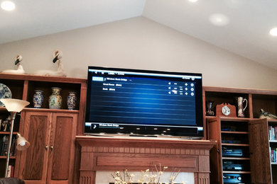 Mid-sized elegant enclosed home theater photo in Other with beige walls and a wall-mounted tv