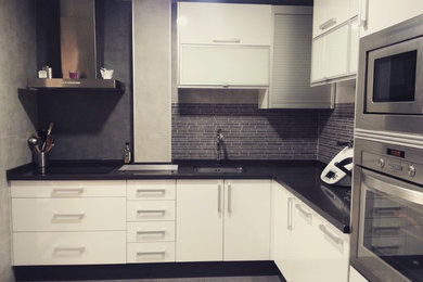 Imagen de cocinas en L contemporánea de tamaño medio cerrada sin isla con fregadero bajoencimera, encimera de cuarzo compacto, electrodomésticos de acero inoxidable, suelo de baldosas de porcelana, suelo gris y encimeras negras