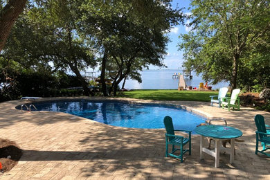 Large stone and custom-shaped pool photo in Other