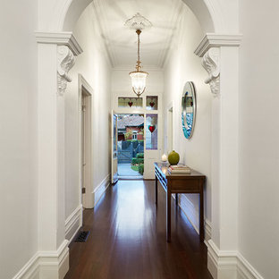 Неиссякаемый источник вдохновения для домашнего уюта: фойе среднего размера в викторианском стиле с белыми стенами, темным паркетным полом, одностворчатой входной дверью и белой входной дверью