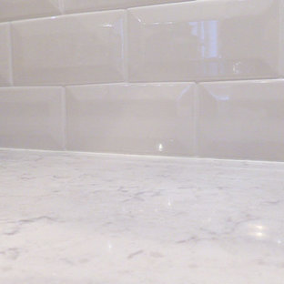 Large traditional kitchen pantry ideas - Inspiration for a large timeless l-shaped dark wood floor kitchen pantry remodel in Baltimore with a farmhouse sink, raised-panel cabinets, white cabinets, quartz countertops, white backsplash, porcelain backsplash, stainless steel appliances and an island