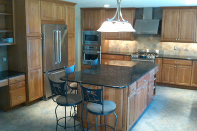 Eat-in kitchen - mid-sized traditional u-shaped slate floor eat-in kitchen idea in Baltimore with raised-panel cabinets, light wood cabinets, granite countertops, multicolored backsplash, ceramic backsplash, stainless steel appliances and an island