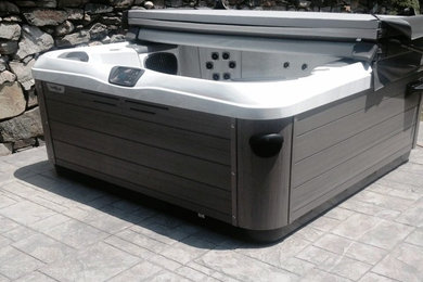 Inspiration for a small traditional backyard rectangular aboveground pool in Bridgeport with a hot tub and stamped concrete.