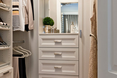 Small transitional women's medium tone wood floor walk-in closet photo in Other with recessed-panel cabinets and beige cabinets