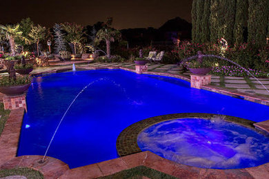 Large backyard custom-shaped hot tub photo in Houston