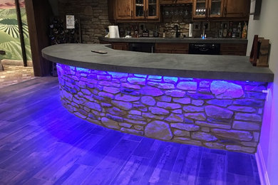 Example of a large country galley gray floor seated home bar design in Other with wood countertops, wood backsplash and brown countertops