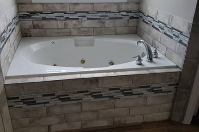Drop-in bathtub - mid-sized transitional master ceramic tile ceramic tile and brown floor drop-in bathtub idea in Raleigh with gray walls