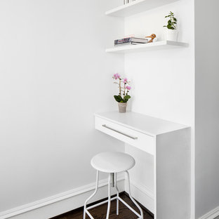 Inspiration for a small modern study in DC Metro with dark hardwood flooring, white walls and a built-in desk.