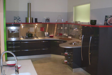 Photo of a medium sized modern l-shaped kitchen/diner with a built-in sink, grey cabinets, laminate countertops, stainless steel appliances, porcelain flooring and grey worktops.