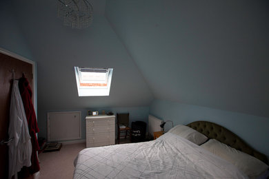 Design ideas for a modern master bedroom in Sussex with blue walls, carpet and beige floors.