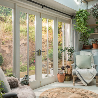 This is an example of a shabby-chic style conservatory in Cornwall with painted wood flooring, a skylight and white floors.