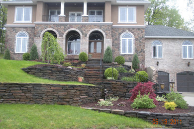 Huge mediterranean three-story stone house exterior idea in Boston with a shingle roof and a brown roof
