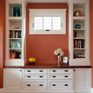 Small arts and crafts home office in Chicago with orange walls, dark hardwood floors and a freestanding desk.