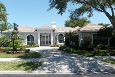 Large coastal gray one-story stucco exterior home idea in Tampa