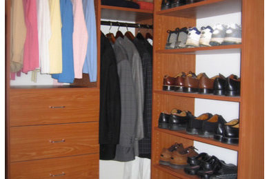 Mid-sized transitional gender-neutral beige floor walk-in closet photo with flat-panel cabinets and medium tone wood cabinets