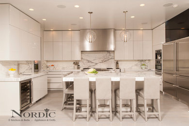 Example of a huge trendy u-shaped porcelain tile eat-in kitchen design in New Orleans with a farmhouse sink, glass-front cabinets, yellow cabinets, yellow backsplash, stainless steel appliances, an island and stone slab backsplash