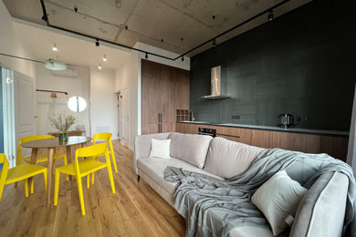 На фото: гостиная комната в стиле лофт с белыми стенами, паркетным полом среднего тона и акцентной стеной