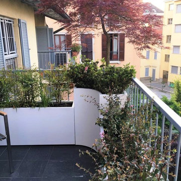 Terrazzo con fioriere, panca e arredi per una famiglia a Milano