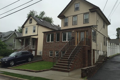 Example of a mid-sized classic beige three-story mixed siding house exterior design in New York with a hip roof and a shingle roof