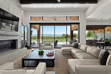 Inspiration for a large contemporary open concept light wood floor and beige floor living room remodel in Boise with white walls, a ribbon fireplace, a concrete fireplace and a wall-mounted tv