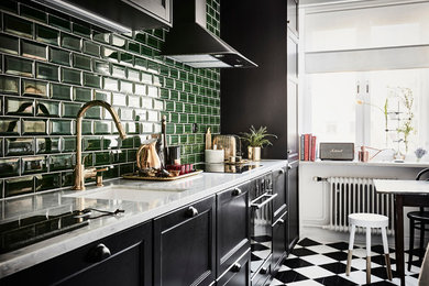 Eclectic single-wall eat-in kitchen in Gothenburg with a single-bowl sink, shaker cabinets, black cabinets, marble benchtops, green splashback, ceramic splashback, stainless steel appliances, no island and multi-coloured floor.