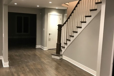 Photo of a mid-sized transitional hallway in Chicago with grey walls, medium hardwood floors and brown floor.