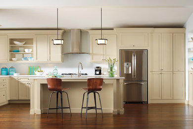 Example of a large transitional u-shaped dark wood floor eat-in kitchen design in Other with an undermount sink, shaker cabinets, beige cabinets, quartz countertops, white backsplash, glass sheet backsplash, stainless steel appliances and an island