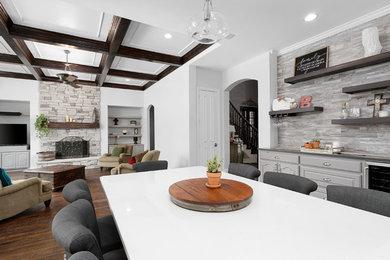 Open concept kitchen - large transitional l-shaped dark wood floor and brown floor open concept kitchen idea in Dallas with an undermount sink, raised-panel cabinets, white cabinets, quartz countertops, white backsplash, porcelain backsplash, stainless steel appliances, an island and white countertops