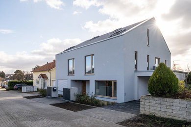 Mittelgroße Moderne Doppelhaushälfte mit Backsteinfassade, grauer Fassadenfarbe, Satteldach, Ziegeldach und grauem Dach in Frankfurt am Main