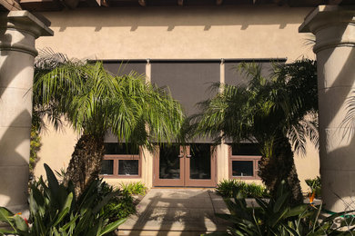 Example of a minimalist beige house exterior design in San Diego with a tile roof