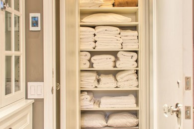 Example of a small classic gender-neutral medium tone wood floor reach-in closet design in Orange County with open cabinets and white cabinets