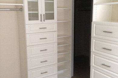 Example of a large transitional gender-neutral ceramic tile walk-in closet design in Toronto with raised-panel cabinets and white cabinets