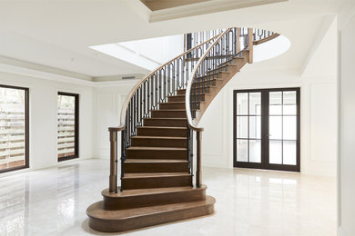 This is an example of a large traditional wood curved staircase in Melbourne with wood risers and wood railing.