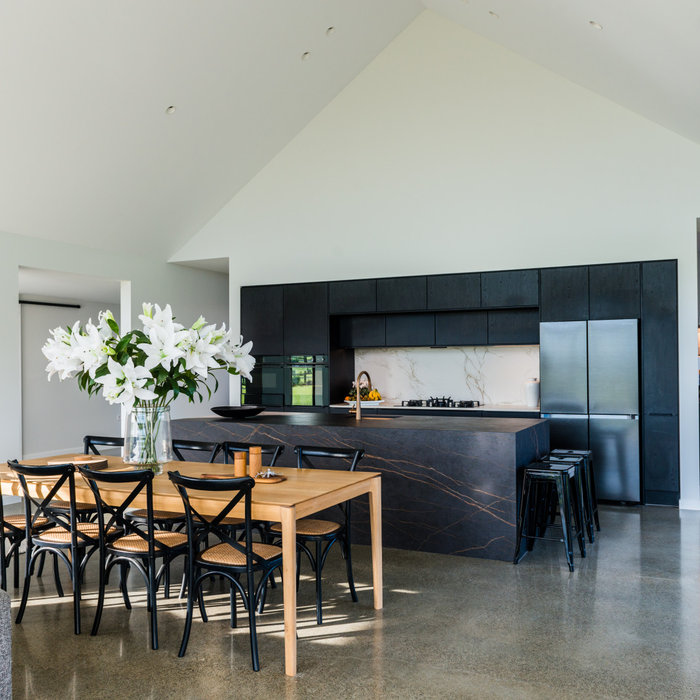 Inspiration for a contemporary concrete floor and vaulted ceiling kitchen/dining room combo remodel in Christchurch with white walls