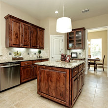 Stained Cabinets, island. Dark cream backsplash and floors