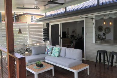 Design ideas for a mid-sized contemporary backyard deck in Brisbane with a roof extension.