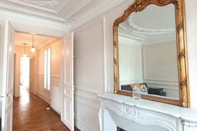 Foto de recibidores y pasillos clásicos renovados de tamaño medio con paredes blancas, suelo de madera oscura y boiserie