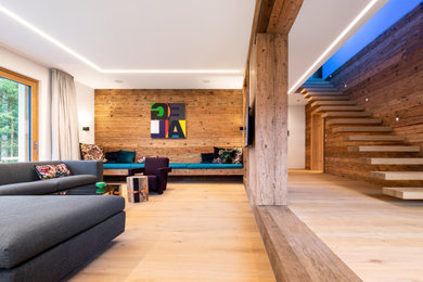 Imagen de salón para visitas abierto minimalista extra grande con suelo de madera clara, televisor colgado en la pared, suelo marrón y boiserie