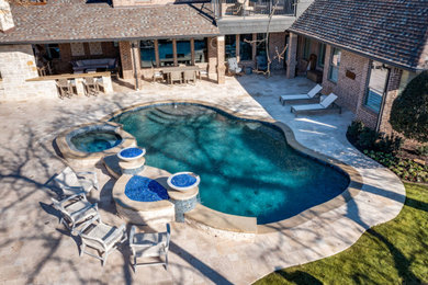 Hot tub - mid-sized backyard stone and custom-shaped hot tub idea in Dallas