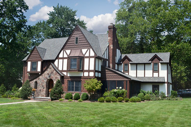 Large traditional brown two-story stucco exterior home idea in New York with a shingle roof